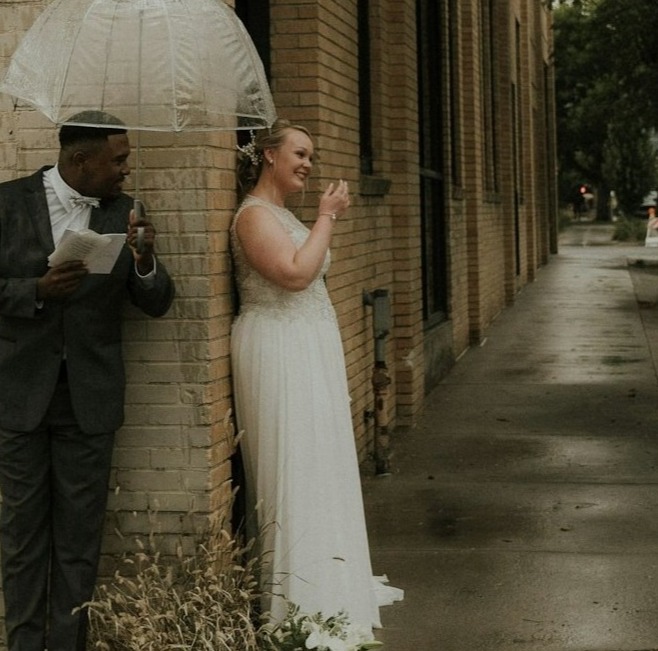 A professional wedding photographer discussing details with a bride and groom, surrounded by wedding album samples. The atmosphere should convey professionalism and attention to detail, with a backdrop of wedding decorations and floral arrangements.