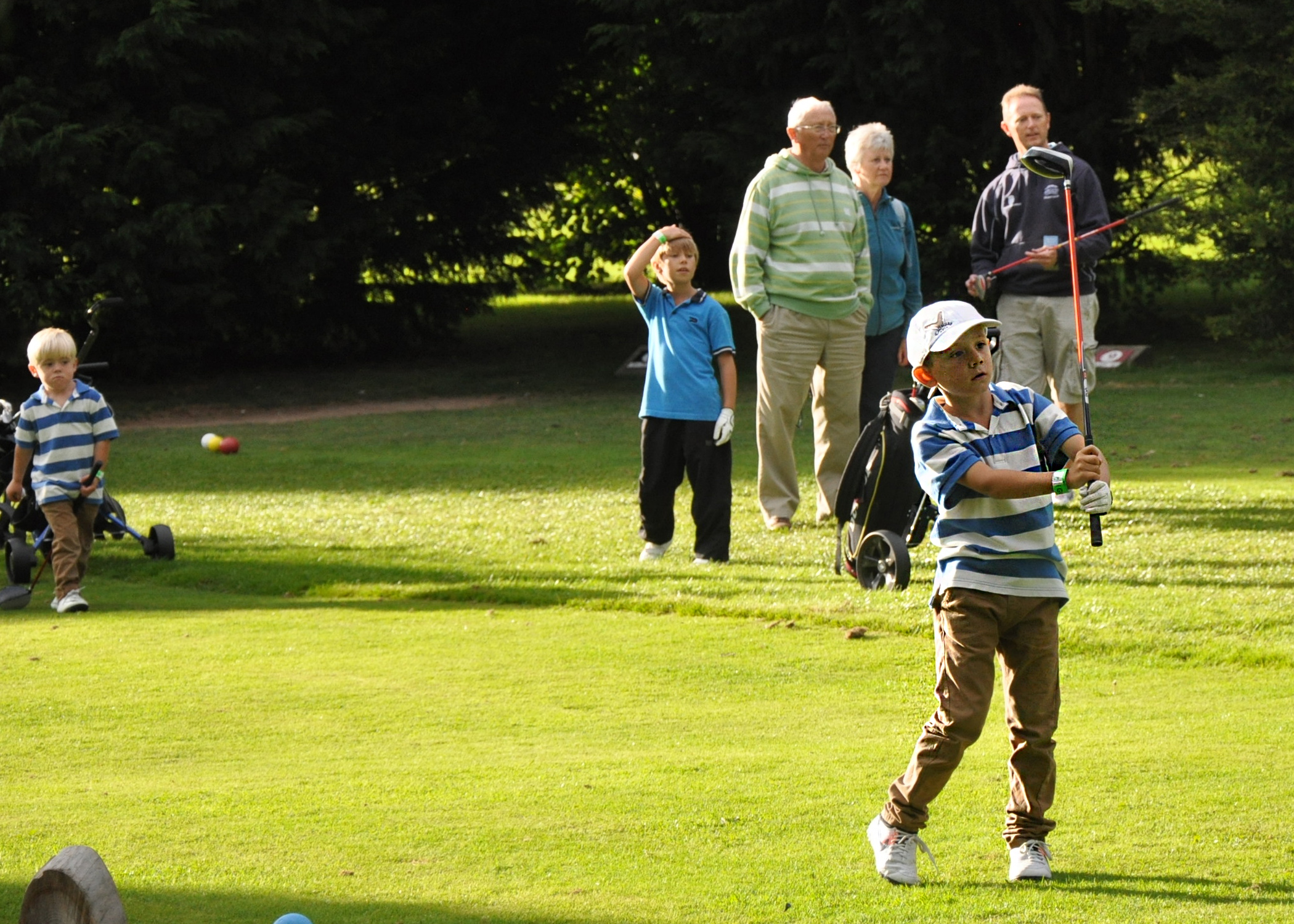 young brother watching older brother play shot