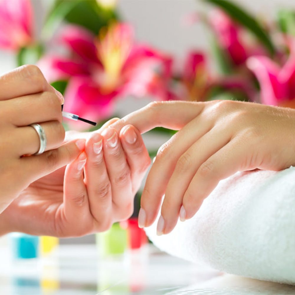 A high-quality, photorealistic image of a luxurious manicure station at Mariposa Nails in Chicago, showcasing elegant nail designs with shellac polish. Include bright lighting, a variety of nail polish colors, and tools laid out in an organized manner, with a client's hand elegantly resting on the table.