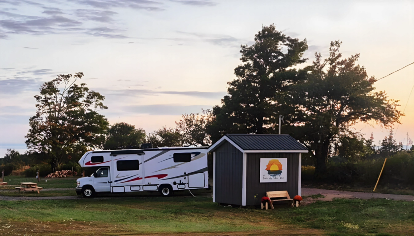 A photorealistic image showcasing the panoramic view of the Bay of Fundy from an RV campsite. The image should focus on the dramatic tides and the vastness of the bay. The sky should be clear and bright, emphasizing the beauty of the natural landscape. The lighting should be natural and vibrant. Include details of the rocky coastline and the rolling tides. The image should convey the scale and majesty of the Bay of Fundy.