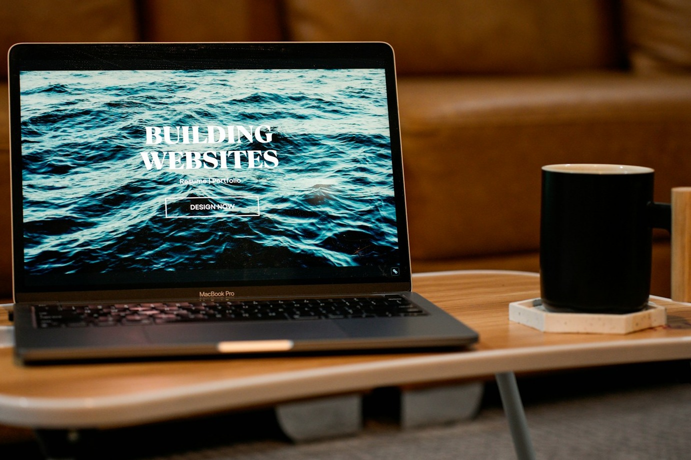 A designer working on a laptop in a modern workspace. The laptop screen displays a website mockup in progress. The surrounding environment is clean and stylish, with a variety of design tools and inspiration boards. The designer is smiling and looks confident as they work on the project, representing a creative and professional approach to website development.