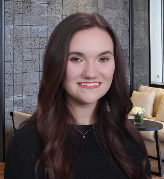 Jewelya Tramontana-Stires smiling warmly in a bright, modern office setting