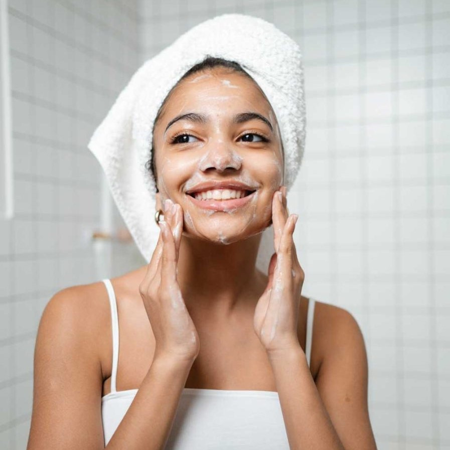 A before-and-after image showing dry, dull skin before washing and then healthy, radiant, and moisturized skin after washing with the Andrographis Paniculata Herbal Cream Soap.  The image should clearly showcase the difference. High-resolution, photorealistic image with consistent lighting in both halves of the image.