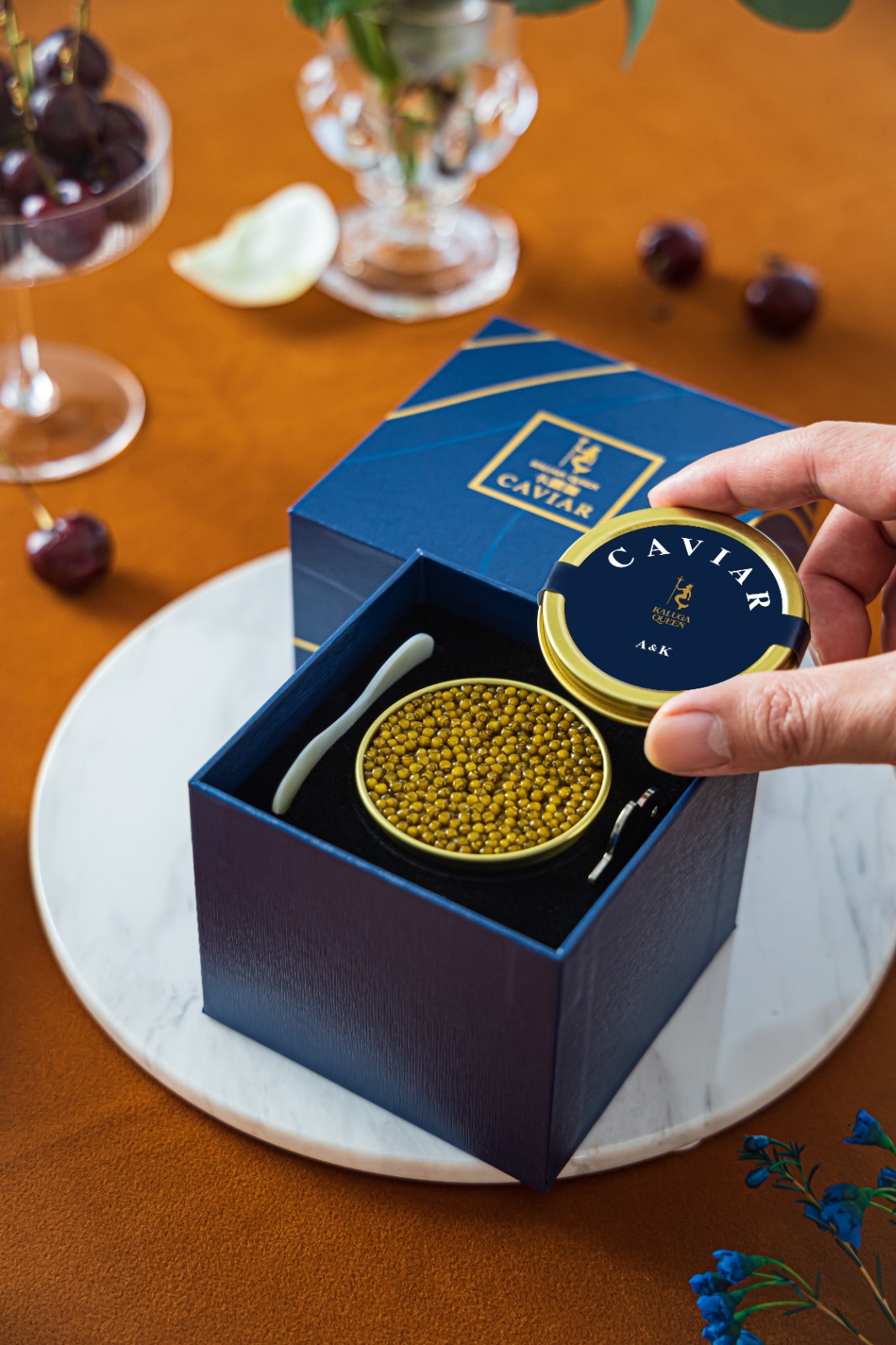 A sophisticated, professional concierge is handing a client a beautifully packaged caviar order. The setting is a luxurious, modern lobby. The concierge should have a warm and attentive demeanor, conveying exceptional customer service. The focus is on the interaction between the concierge and client, emphasizing the personalized and seamless experience.