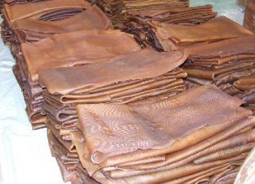 A photorealistic close-up of various types of rubber materials arranged artfully on a dark surface. Lighting should be dramatic, highlighting the textures and colors. The background should be blurred to focus attention on the rubber. Style is photorealistic with a focus on detail. 4K resolution.