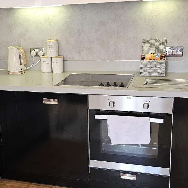 A hyperrealistic, ultra-detailed image of a bright and airy living room after a thorough spring cleaning. Soft, warm sunlight streams through sheer curtains, creating a welcoming atmosphere.  The color palette features soft pastels, creams, and whites, with pops of color from fresh flowers in a vase.  The camera angle is slightly low, emphasizing the spaciousness and cleanliness of the room. Textures are incredibly detailed, showcasing the softness of the plush sofa, the smoothness of the hardwood floor, and the sparkle of the freshly cleaned windows.  The scene includes a comfortable sofa, neatly arranged bookshelves, and a coffee table with a few carefully chosen decorative items.  The overall mood is inviting, cheerful, and relaxing. The background includes lush green plants and hints of sunlight adding to the brightness of the room.  The style should emulate the work of renowned lifestyle photographer, Matthew Williams, emphasizing natural light and airy composition.  8K resolution is required to showcase hyperrealism and texture detail.