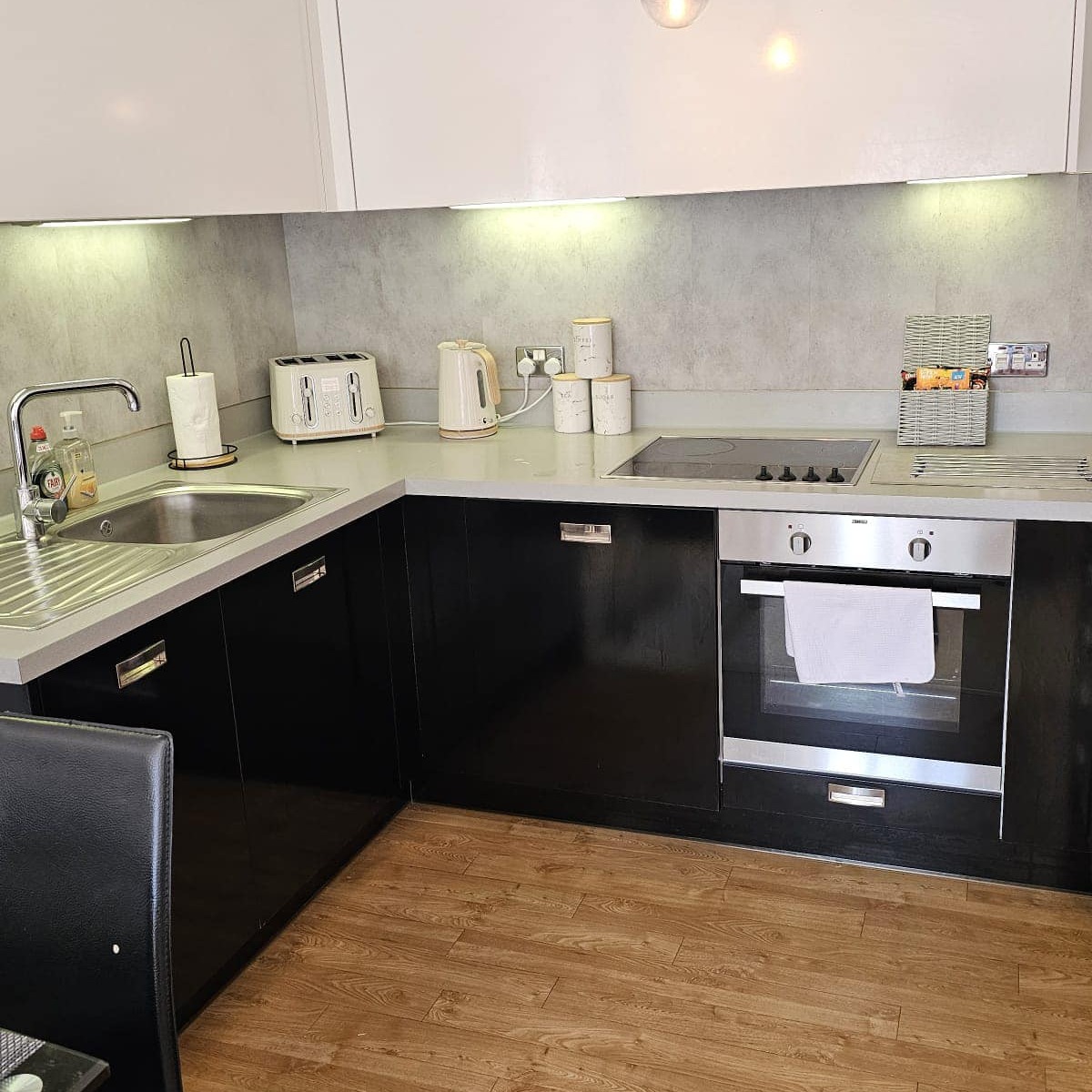 A photorealistic image depicting a cozy living room, spotlessly clean and welcoming.  A family is happily interacting; children are playing, and parents are relaxing on a comfortable sofa.  Natural light fills the room, highlighting the cleanliness and creating a warm, inviting atmosphere. The image should evoke feelings of comfort, relaxation, and family togetherness.