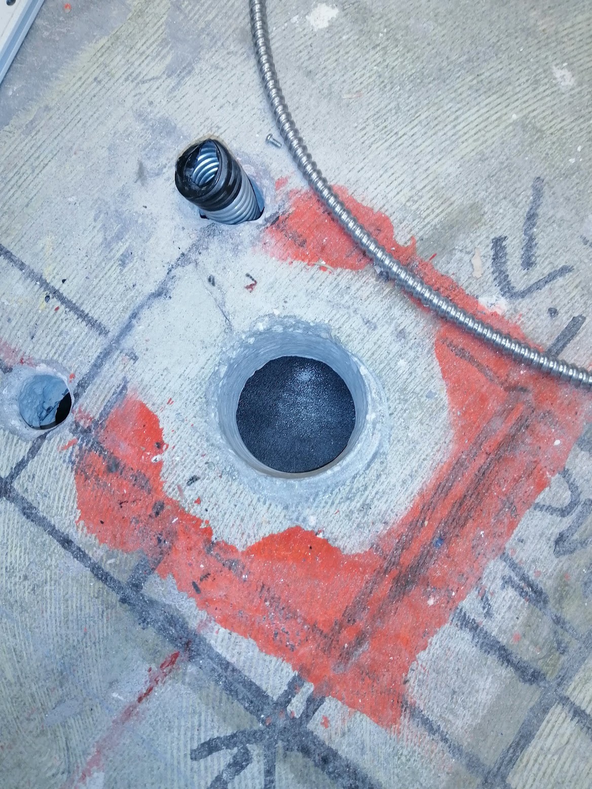 A photorealistic image showing a clean and organized construction site where core drilling is being performed. The image should show minimal dust and debris, showcasing the neatness and efficiency of the process. The overall feeling should be one of professionalism and orderliness. The colors should be muted and realistic, avoiding overly vibrant or unnatural tones. The camera angle should be from a slightly elevated position to give a good overview of the site. The style should be similar to architectural photography.