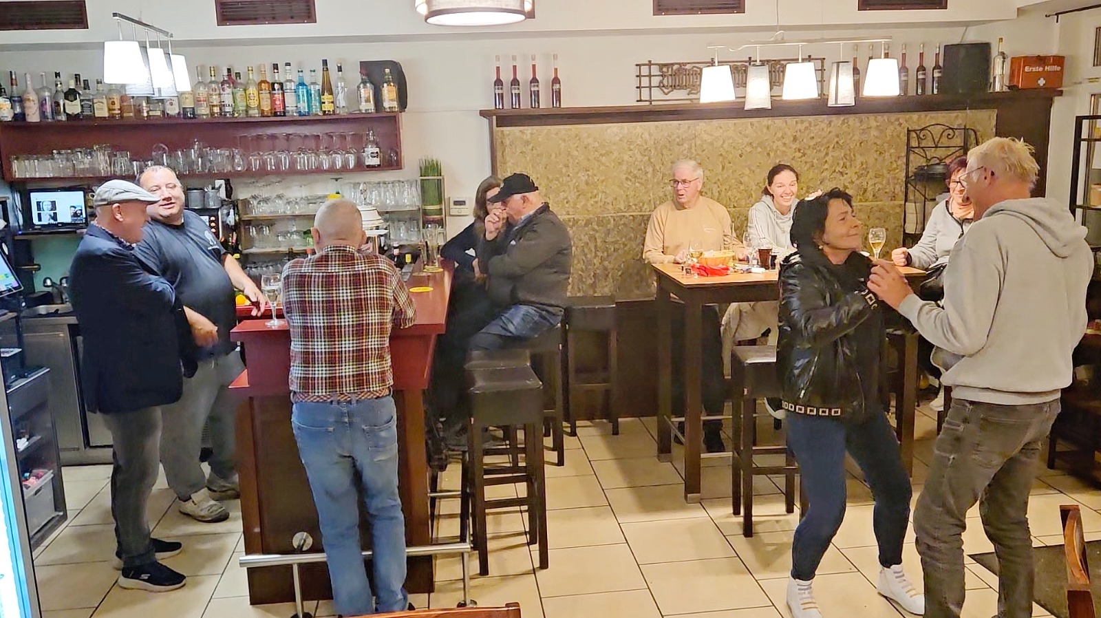 An interior shot of the 'Stüberl', focusing on the cozy atmosphere with warm lighting, wooden furniture, and traditional decorations. Capture the feeling of a welcoming and comfortable space.