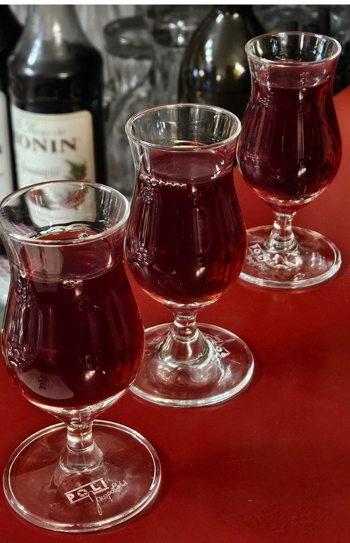 A bartender expertly preparing a colorful cocktail, with a well-stocked bar in the background. The lighting should be moody and inviting.