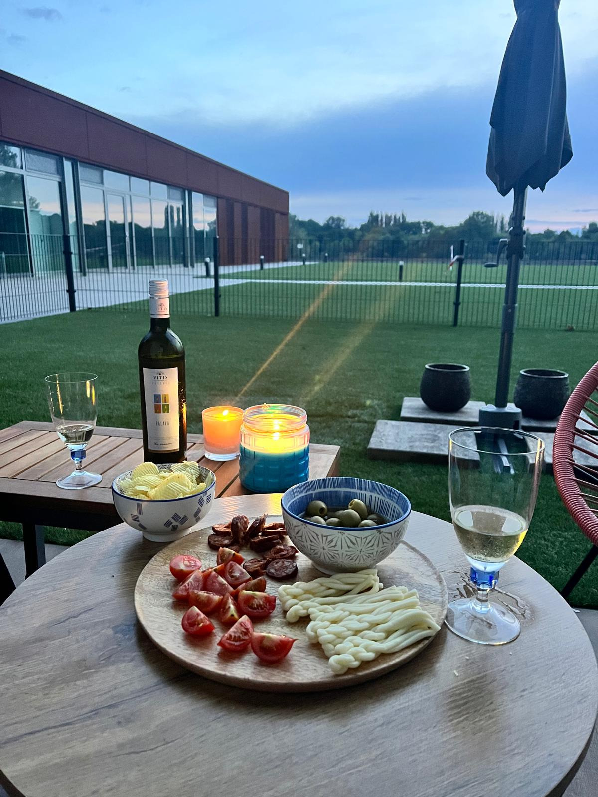 Generate a photorealistic image of a luxurious apartment bedroom with a king-size bed, large windows looking over a beach and ocean. Use warm, inviting colors and natural lighting. The style should match high-end hotel room photography