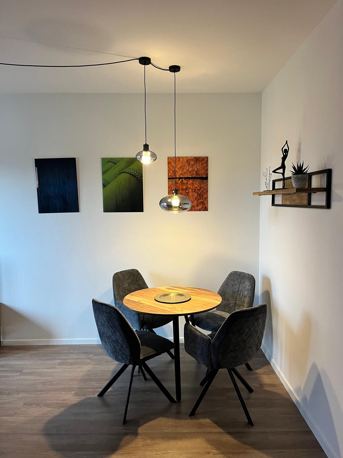 Generate a photorealistic image of a modern kitchen in a holiday apartment. The kitchen should be well-equipped and have beautiful countertops and appliances. Use natural light and a slightly elevated camera angle.