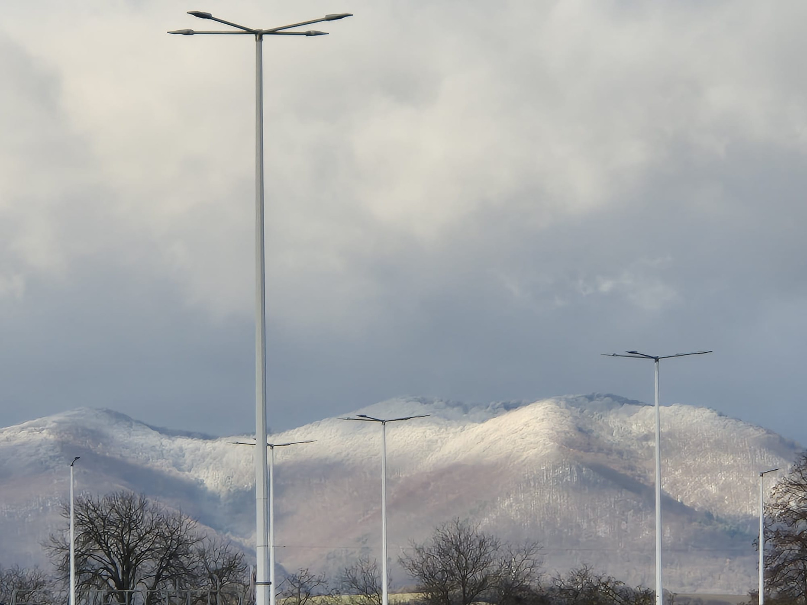 Create a photorealistic image of a family enjoying a meal together in a holiday apartment. Highlight the spaciousness and amenities, emphasizing a cozy and family-friendly environment