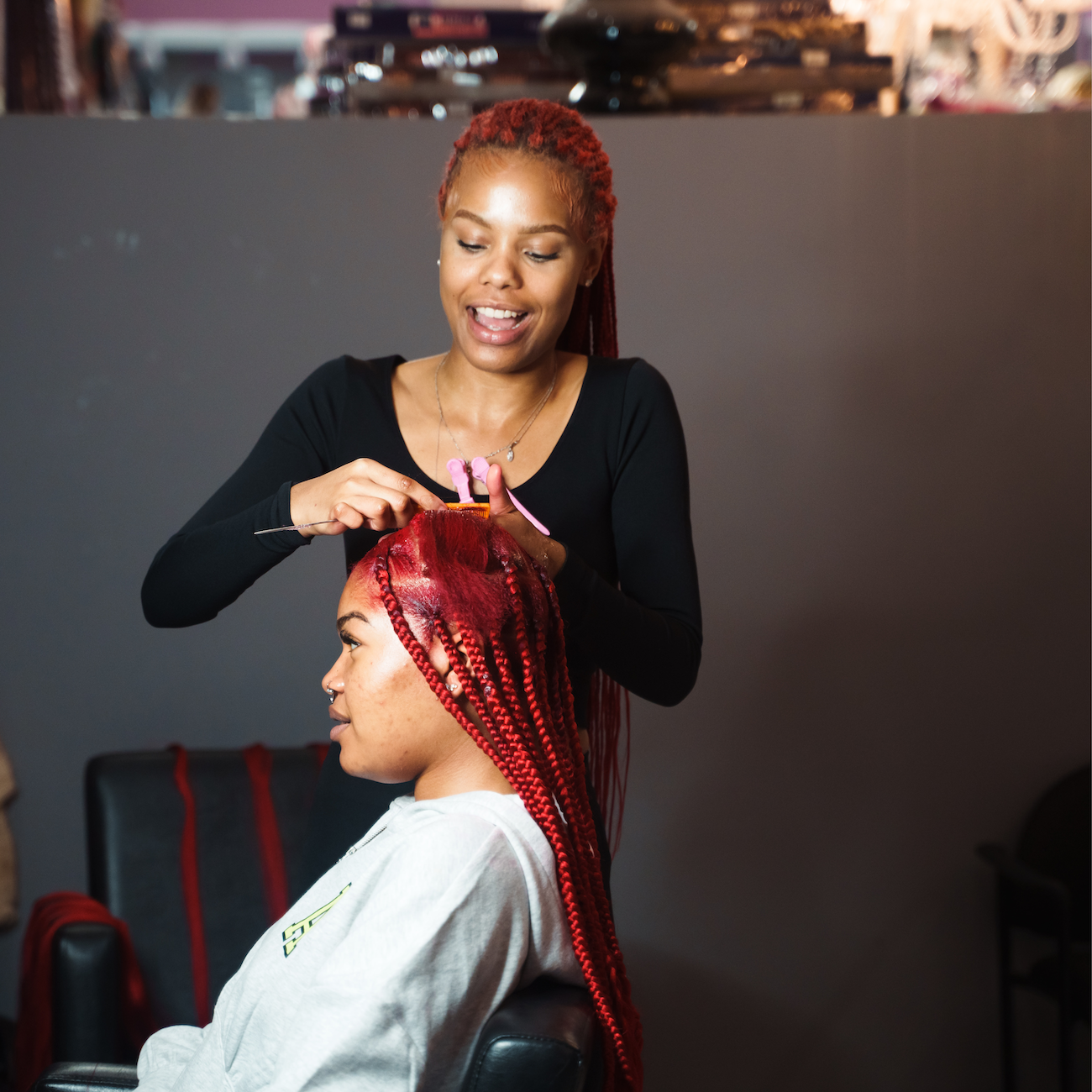 Show an engaging scene of Jennifer applying a rich color treatment on a client’s hair, highlighting the vivid hair color swatches around them. The lighting should be bright and cheerful, emphasizing the transformation process. Capture the moment with hyperrealistic detail in 8K, focusing on the beautiful textures and colors of the hair.