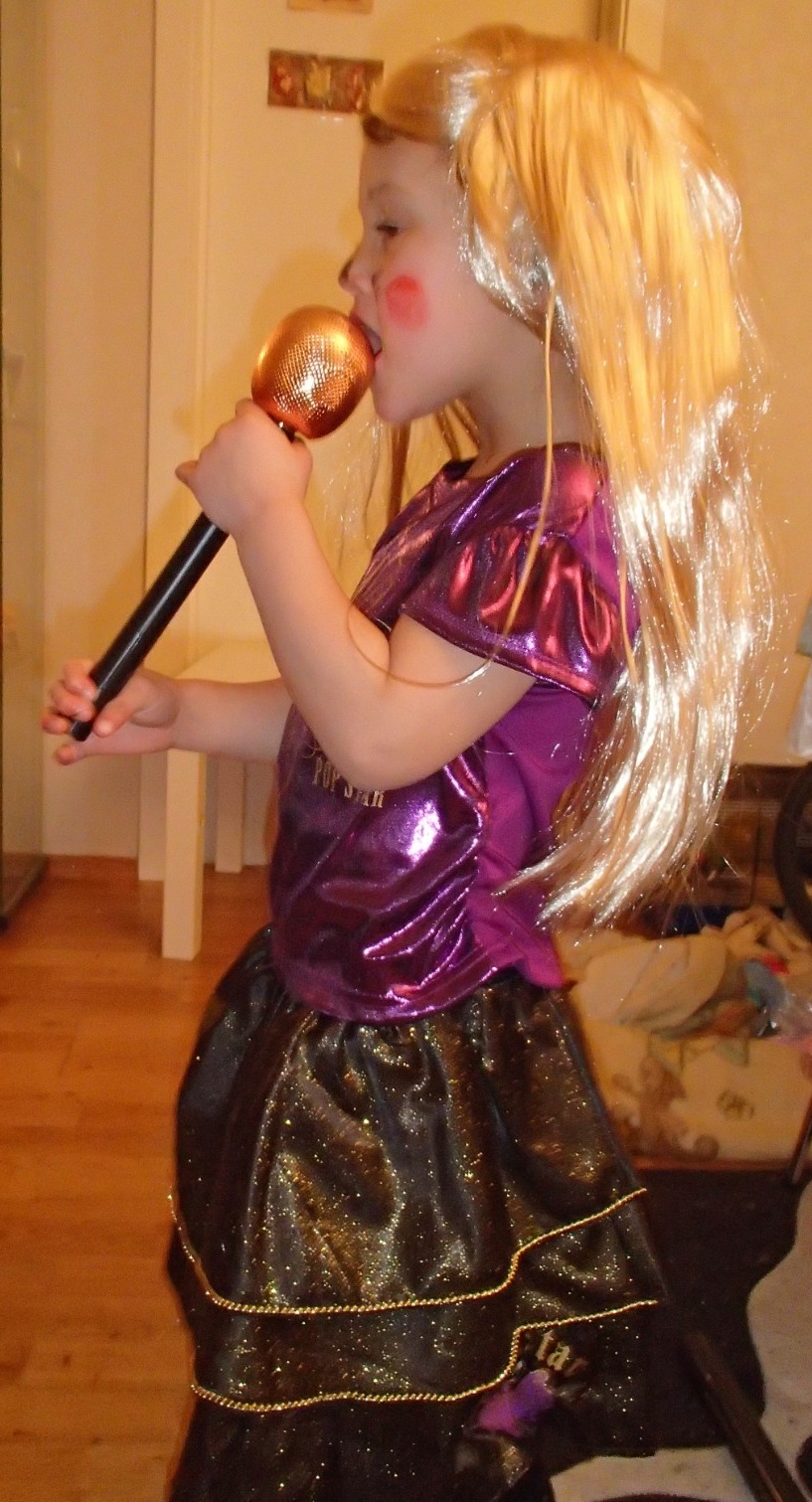 Craft a visually empowering representation of Ester Elin Lima Amdal 'Making My Own Music.' Imagine a spotlight shining on a stage, illuminating a microphone and a musical instrument (guitar, piano, etc.). The background could feature stylized images of musical notes, sound waves, and cheering crowds. Use a bold and vibrant color palette to reflect her passion and creativity. Include elements like sheet music, recording equipment, and musical awards to symbolize her accomplishments. The overall composition should feel inspiring and aspirational, encouraging viewers to pursue their own musical dreams. Add a subtle vignette effect around the edges to focus attention on the stage.