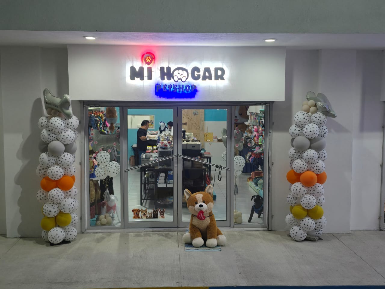 A photorealistic, ultra-high quality 8K resolution image depicting a heartwarming scene in a vibrant pet shop.  The composition should focus on a diverse array of happy, healthy pets interacting playfully with each other and their owners.  The lighting should be bright and natural, creating a welcoming atmosphere. The color palette should be warm and inviting, with a focus on soft, pastel shades and natural wood tones. The camera angle should be slightly elevated, providing a broad view of the shop's interior. Texture details are crucial: show the soft fur of the animals, the smooth surfaces of the pet supplies, and the warm texture of the wooden shelves. The environment should be clean, organized, and filled with various pet products neatly displayed. Relevant props could include colorful pet toys, comfortable pet beds, and informative signage. The overall style should evoke a sense of trust, care, and happiness.  The image should be hyperrealistic, showcasing incredibly detailed textures and a lifelike representation of the scene.  Style references could include the work of renowned wildlife photographers such as Frans Lanting or Steve McCurry, focusing on the emotional connection between humans and animals.  The technical specifications should be 8K resolution, hyperrealistic rendering, and a focus on sharp detail and lifelike textures.