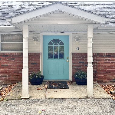A 4K resolution, high-quality photograph depicting the exterior of The Venue At Victory Court. The building is modern and inviting, featuring clean lines and large windows that allow natural light to filter in. The landscaping is meticulously maintained, with lush greenery and calming water features. The entrance is welcoming, with a clear view of the reception area, hinting at the serene and professional atmosphere within. The overall impression is one of sophistication, tranquility, and advanced healthcare. The image should convey a sense of trust and well-being. Focus on natural light and warm tones to create an inviting atmosphere. Style reference: Architectural photography with a focus on health and wellness.