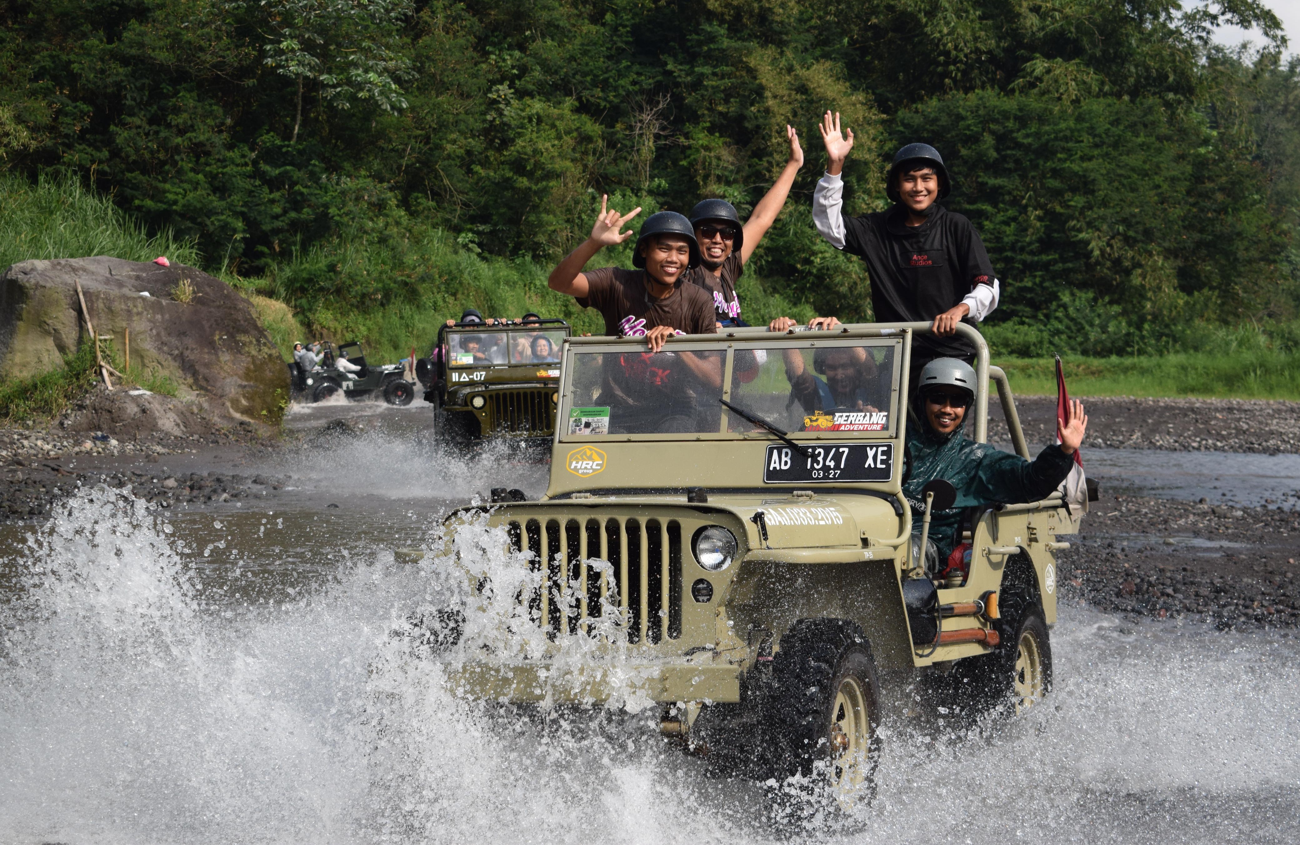 A heartfelt image of tourists sharing their stories and adventures after the Jeep journey, sitting around a campfire with Mount Merapi in the background. The scene should capture the warmth and camaraderie among the group, showcasing their animated expressions and gestures. The firelight should illuminate their faces and create a cozy atmosphere. The backdrop of the volcano, enveloped in twilight, should add a touch of magic. Aim for high-quality details that evoke feelings of nostalgia and connection.