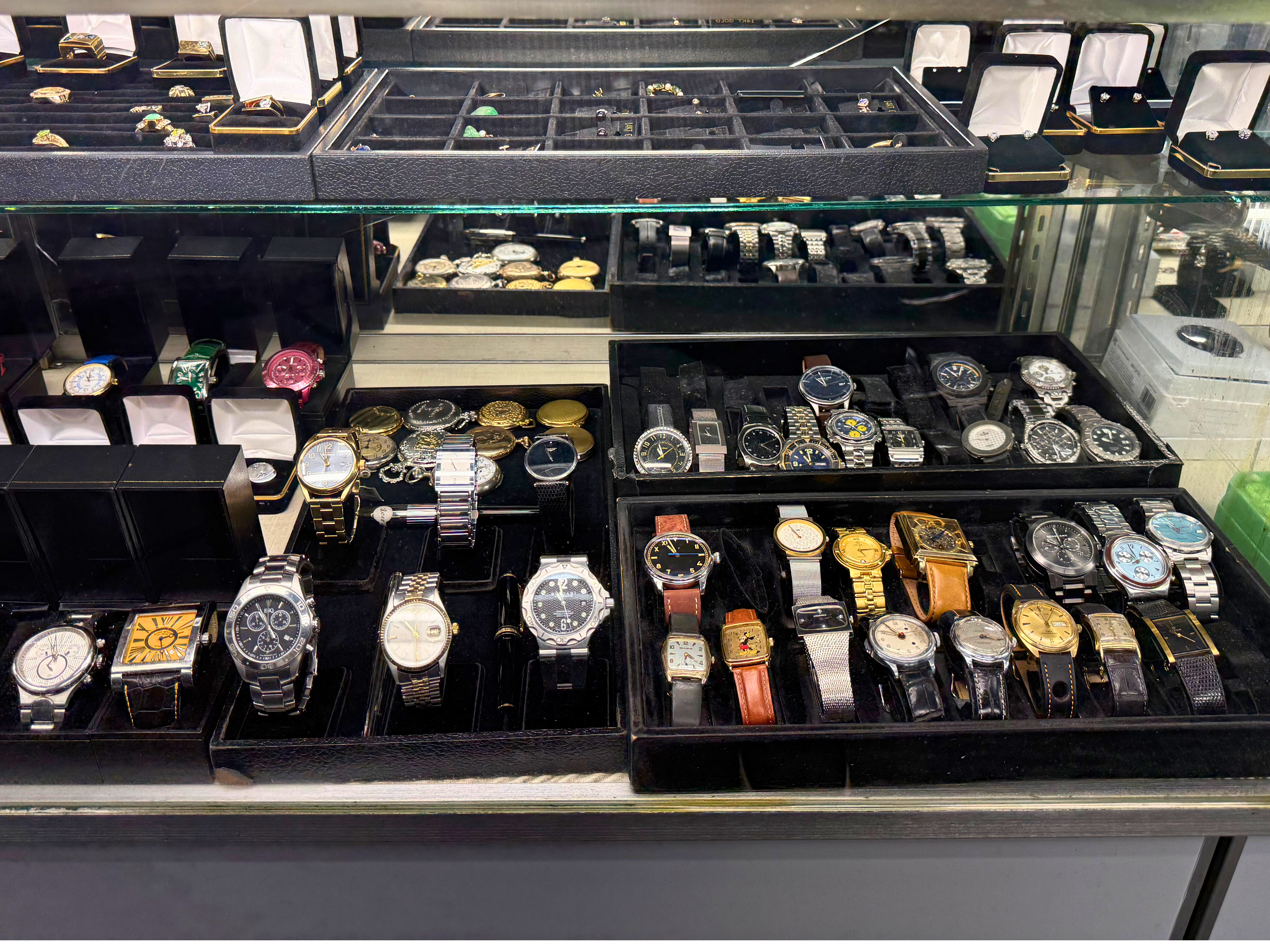 A close-up image displaying a curated collection of vintage watches and jewelry pieces. The lighting should be warm to accentuate the pieces' vintage appeal, while highlighting fine details of the design and craftsmanship.