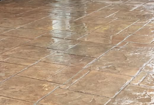 A photorealistic close-up image of a concrete technician using specialized tools to smooth and finish a large concrete floor. Focus on the details of the tools and the precision of the worker's movements. Use industrial lighting and a neutral color palette.