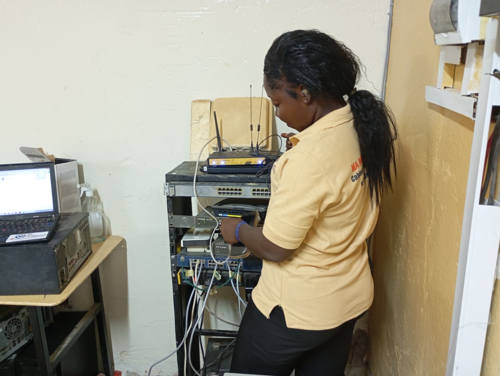 Create a photorealistic image showcasing a team of IT professionals working on a complex network infrastructure. They are gathered around a server rack, using diagnostic tools to monitor performance and troubleshoot issues. The lighting should be bright and technical, highlighting the precision and expertise involved. Colors should be cool and professional, reflecting the reliability and efficiency of the services. Camera angle: medium shot to show the team's collaboration and the scale of the infrastructure. Props: server racks, diagnostic tools, laptops displaying network data. Style: modern and efficient. This image should convey the comprehensive IT services offered by Mit-Technologie.