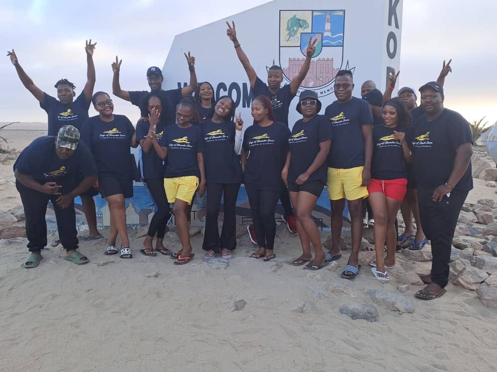 Create a photorealistic image of a group of friends and family enjoying a vacation together. They should be laughing, smiling, and participating in a fun activity. The background should showcase a scenic location, such as a beach or a mountain. The lighting should be bright and cheerful, capturing the joy and excitement of group travel. The color palette should be vibrant and diverse, reflecting the personalities of the travelers. The overall style should emphasize the benefits of group discounts and the joy of traveling with loved ones.