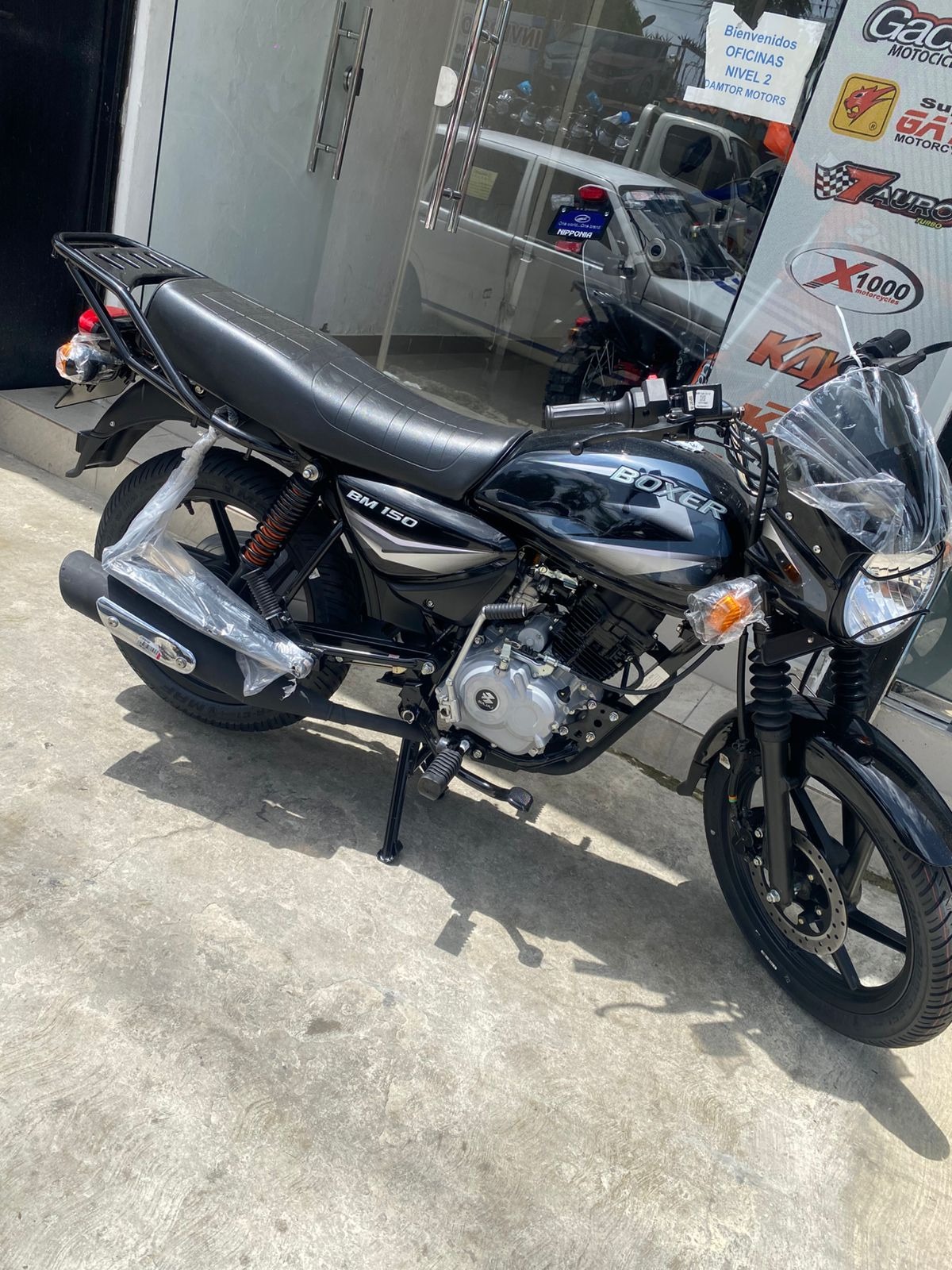 Depict a consultant sitting across a desk from a potential customer, both smiling and looking at a motorcycle brochure. This illustrates personalized support in finding the best credit solution.