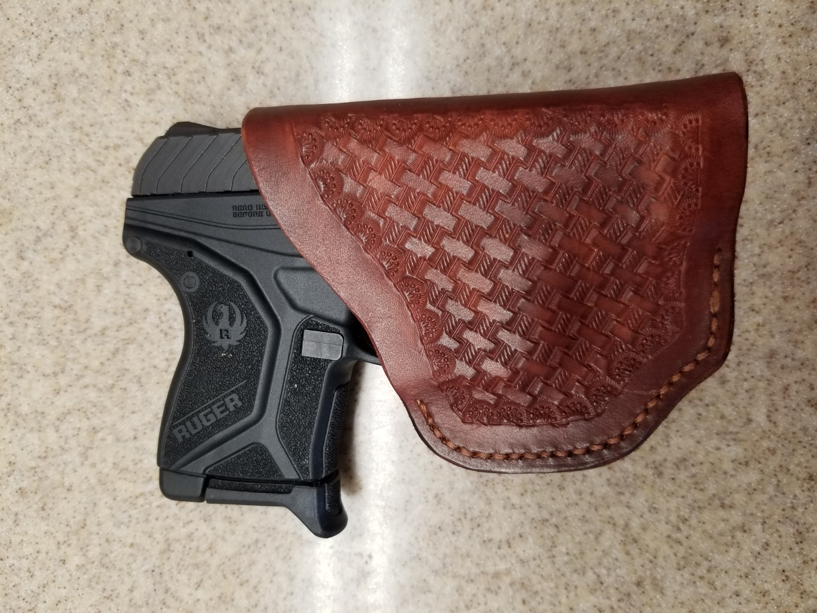 Depict an array of custom leather goods, including pouches, knife sheaths, and small accessories, arranged artfully on a workbench. Tools and raw materials surround the finished products, subtly hinting at the crafting process. Warm, natural light emphasizing the leather's textures and the overall artisanal feel. Style: Rustic and authentic product photography.