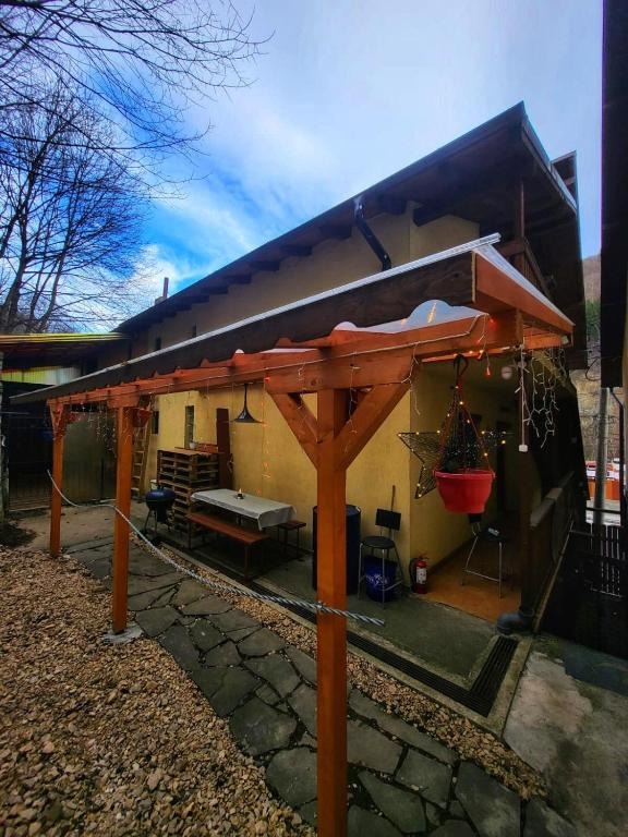 Imagine the garden surrounding "Casa cu 2 Dormitoare La Simo". Capture a vibrant scene with lush greenery, colorful flowers, and a small pond. A wooden bench invites relaxation. Butterflies flutter among the flowers. The lighting is bright and sunny, creating a cheerful and inviting atmosphere. Focus on the textures of the leaves, the petals, and the water. The camera angle is slightly elevated, offering a wide view of the garden. The image should evoke a sense of tranquility and natural beauty. Aim for a photorealistic, high-quality image.