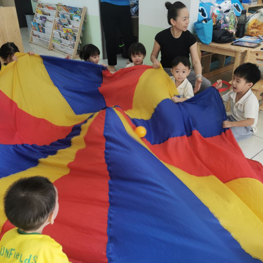 A vibrant image of children engaging in a music class, playing instruments and singing. The lighting is bright and energetic. The camera angle is a wide shot, capturing the group activity. Style: Action Photography.