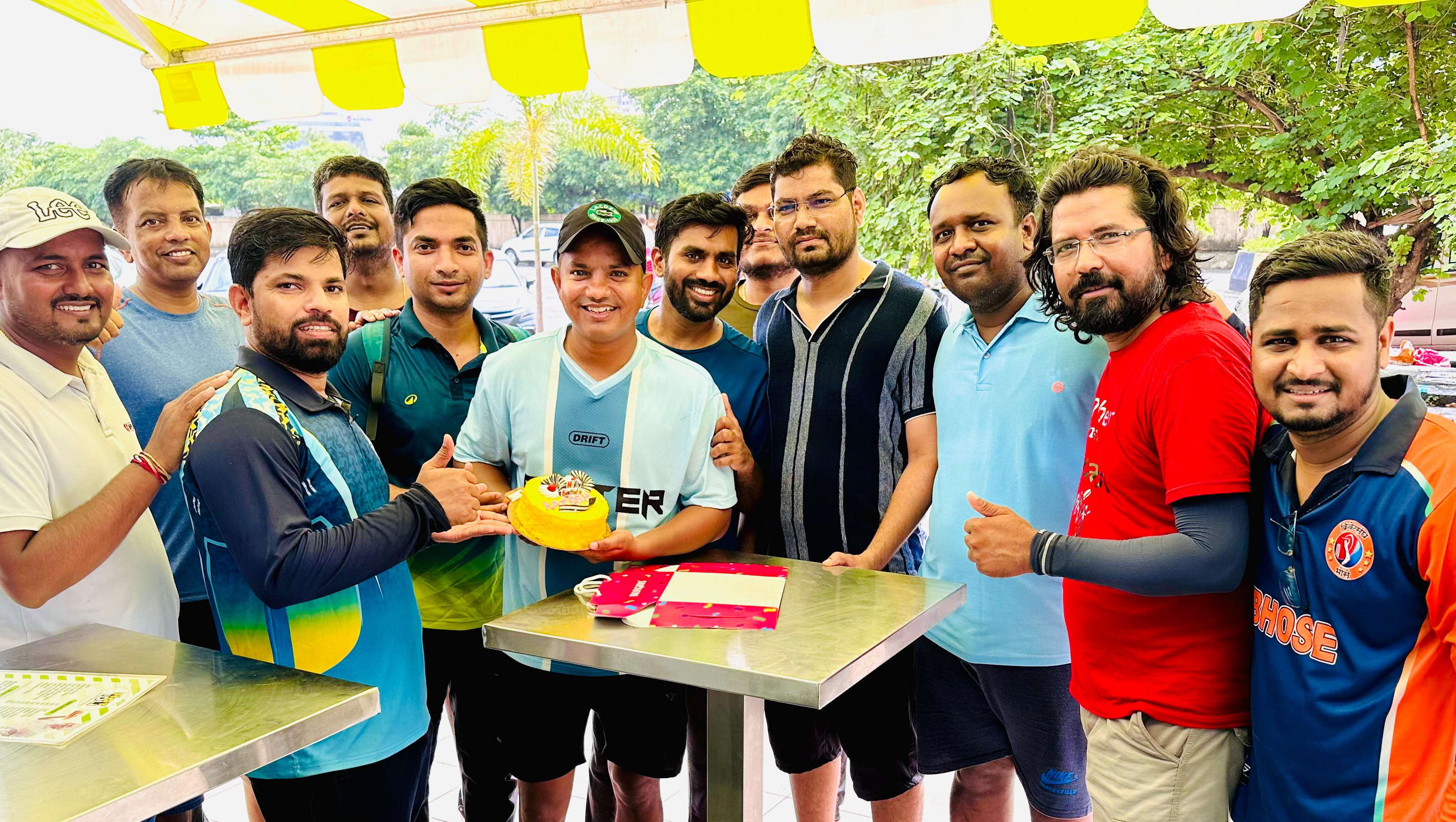 Create a photorealistic 4K image depicting a group of diverse cricket players from Ulwe Satarkar celebrating a successful play. The players are mid-cheer, some with arms raised in victory, set against a backdrop of a cricket field and the Ulwe skyline. The lighting is natural and warm, capturing the early morning sunlight. The composition should be dynamic, emphasizing the teamwork and camaraderie of the group. Focus on details such as sweat on the players' faces, the texture of the cricket ball, and the vibrant colors of their jerseys. This image should be high quality and evoke a feeling of unity and achievement. Style references: Sports photography with a focus on human connection.