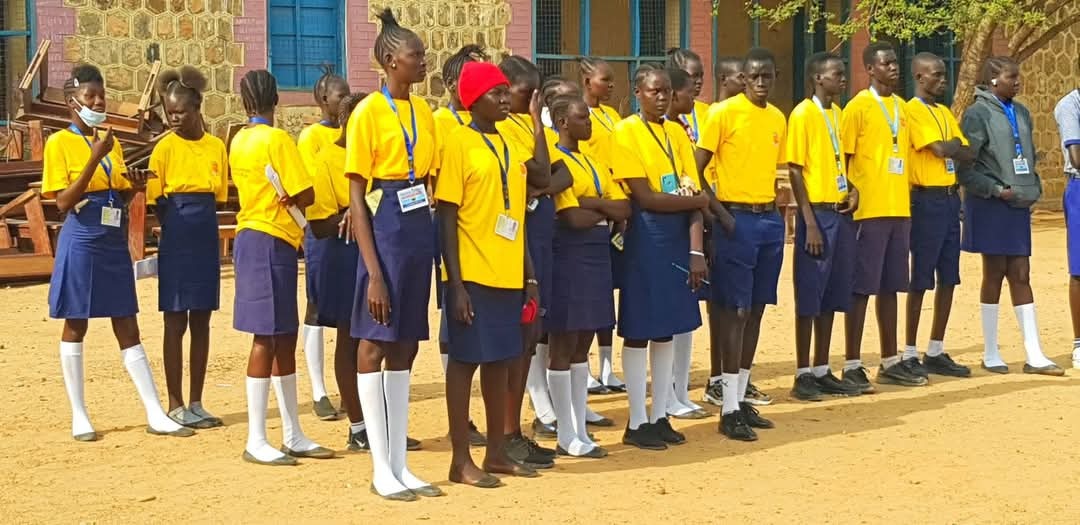 A photorealistic image capturing primary school students collaborating on a science project outdoors in a garden setting. Sunny, warm lighting. The camera angle should be slightly low, making the students appear empowered. 4k resolution. Focus on collaborative learning and nature.