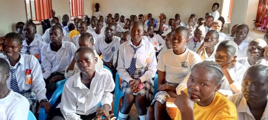 A photorealistic image of secondary school students engaged in a debate in a modern, well-equipped classroom. The lighting is professional and focused. Camera angle should be eye-level, conveying the seriousness of the discussion. 4k resolution. Style: Academic and engaging.
