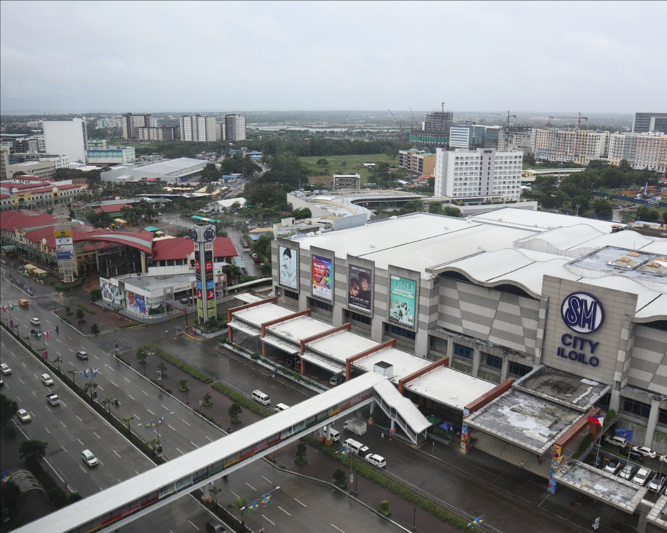 Create a photorealistic image of a modern condo balcony overlooking a dazzling cityscape at night. Soft string lights are draped around the railing. The perspective is from inside the condo, looking out. Style: Modern, upscale. Details: Comfortable outdoor seating, a small table with wine glasses, twinkling city lights. 4K resolution.