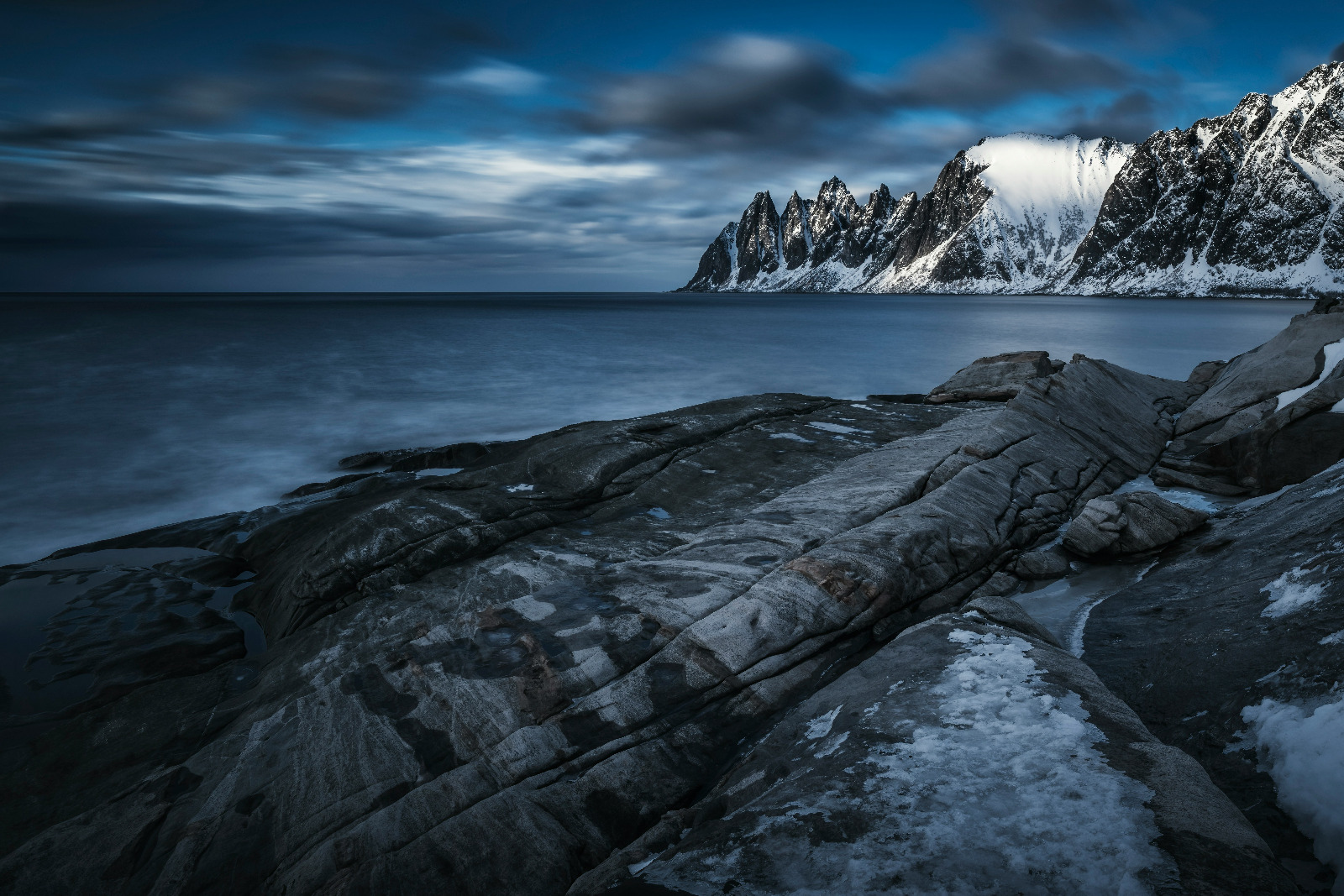 Create a photorealistic, ultra-high quality header image capturing the essence of 'Arctic Cruise in Norway AS'. The composition features a majestic Arctic cruise ship navigating through serene waters, flanked by towering snow-capped mountains illuminated by the soft glow of the Arctic sun. The foreground includes icy blue waters reflecting the sky, while the background presents a breathtaking panorama of dramatic cliffs and quaint fishing villages. The lighting is golden hour, casting warm hues of orange and pink across the scene. Textures should exhibit the rough surfaces of ice and the smooth finish of the ship, enhancing the hyperrealistic quality of the image. Aim for 8K resolution, showcasing the stunning details of this Arctic landscape.