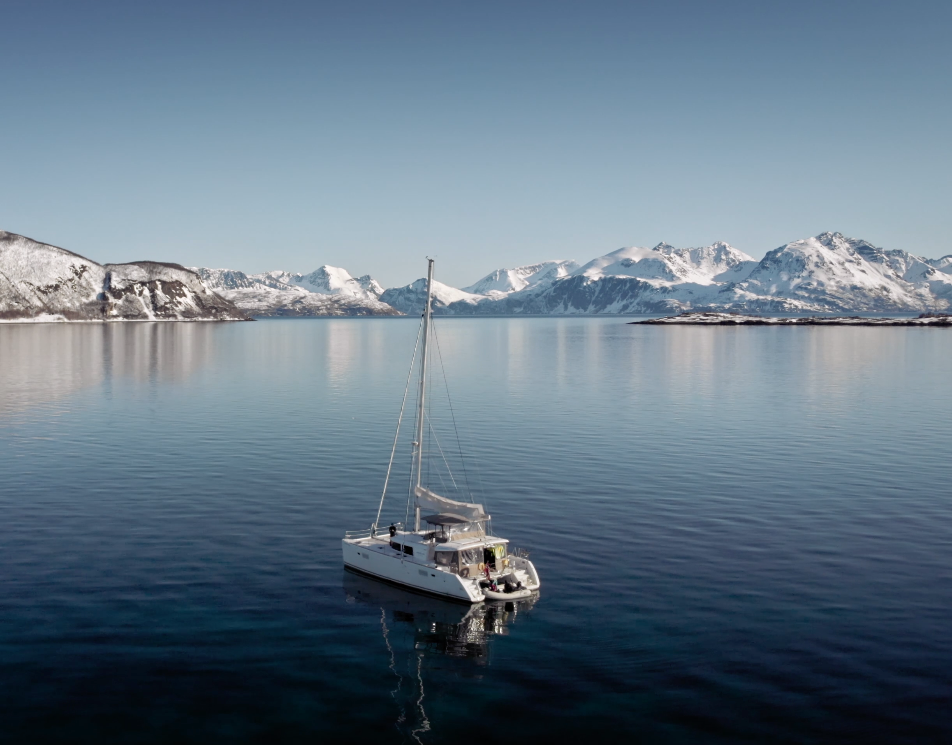 Create a photorealistic, ultra-high quality header image capturing the essence of 'Arctic Cruise in Norway AS'. The composition features a majestic Arctic cruise ship navigating through serene waters, flanked by towering snow-capped mountains illuminated by the soft glow of the Arctic sun. The foreground includes icy blue waters reflecting the sky, while the background presents a breathtaking panorama of dramatic cliffs and quaint fishing villages. The lighting is golden hour, casting warm hues of orange and pink across the scene. Textures should exhibit the rough surfaces of ice and the smooth finish of the ship, enhancing the hyperrealistic quality of the image. Aim for 8K resolution, showcasing the stunning details of this Arctic landscape.