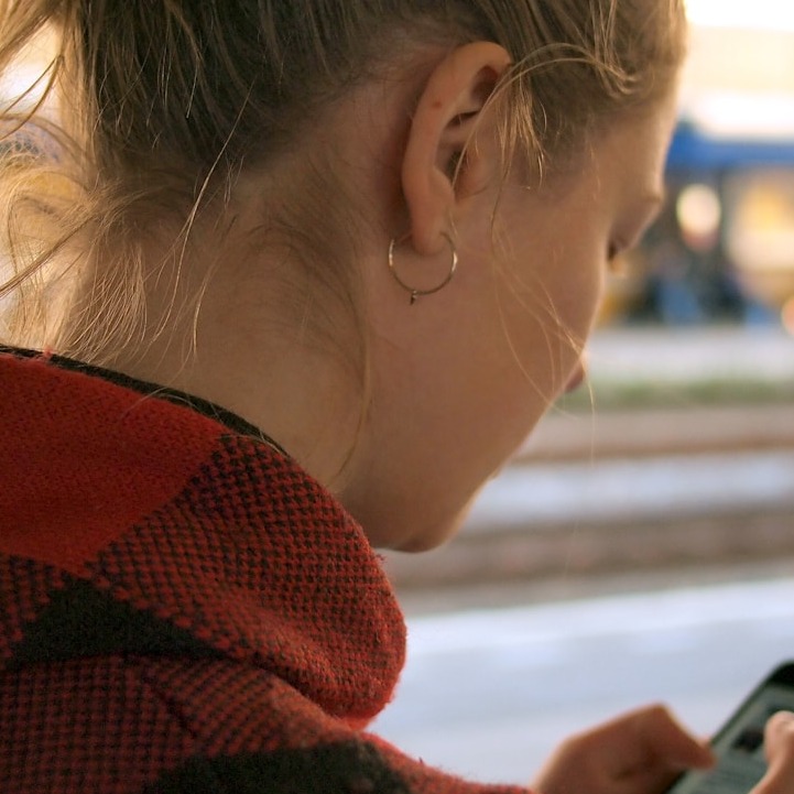 A user interacting seamlessly with a PWA on a smartphone. The focus is on the smooth transitions and intuitive interface. The background features blurred elements of everyday life, showcasing the app's integration into the user's routine. Use a natural, candid style to emphasize the ease of use.