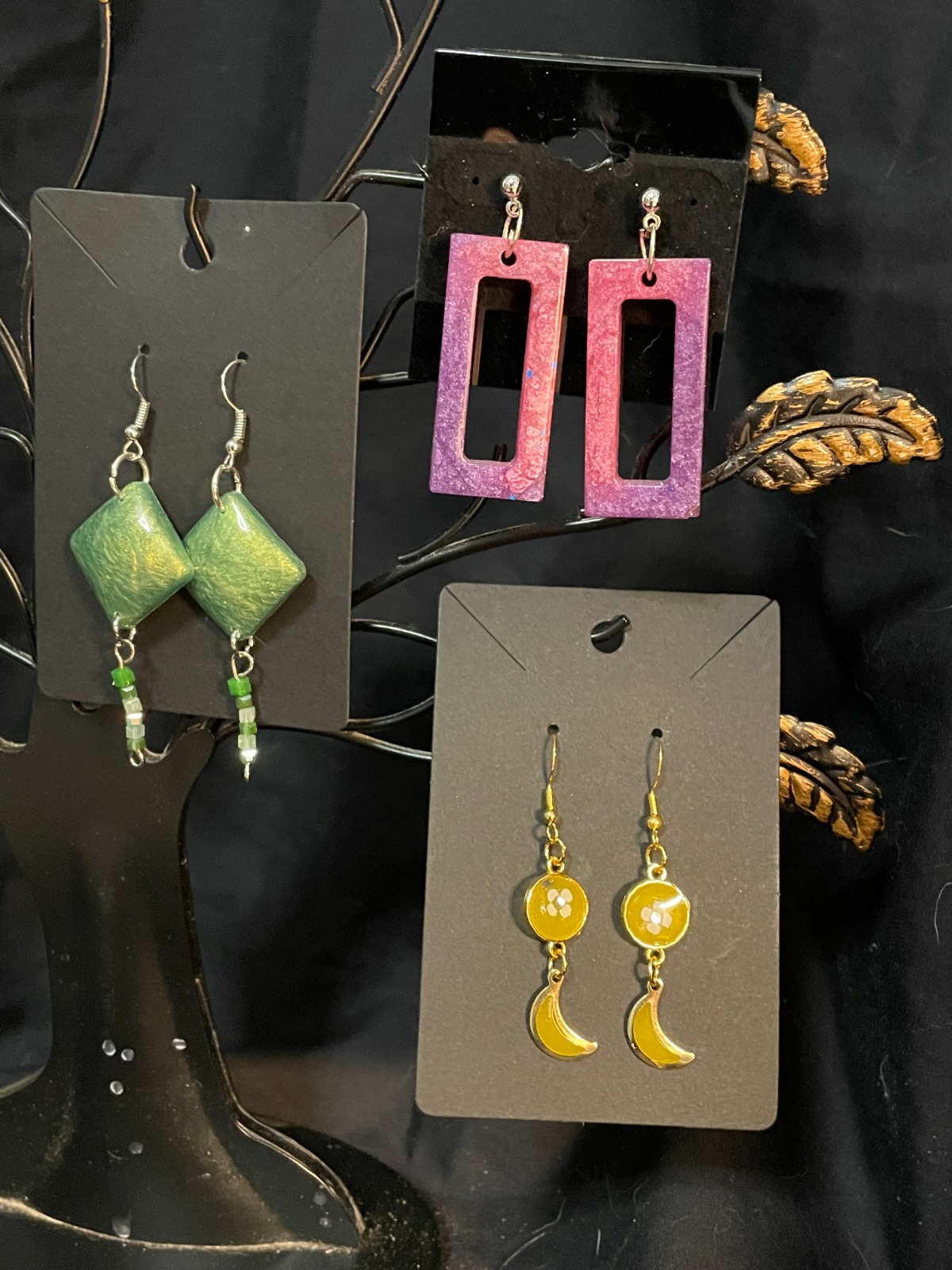 A diverse collection of resin art pieces displayed on a table. The pieces range in style from minimalist to bohemian. The lighting is soft and even. Color palette: varied, reflecting the different styles. 4K resolution, photorealistic.