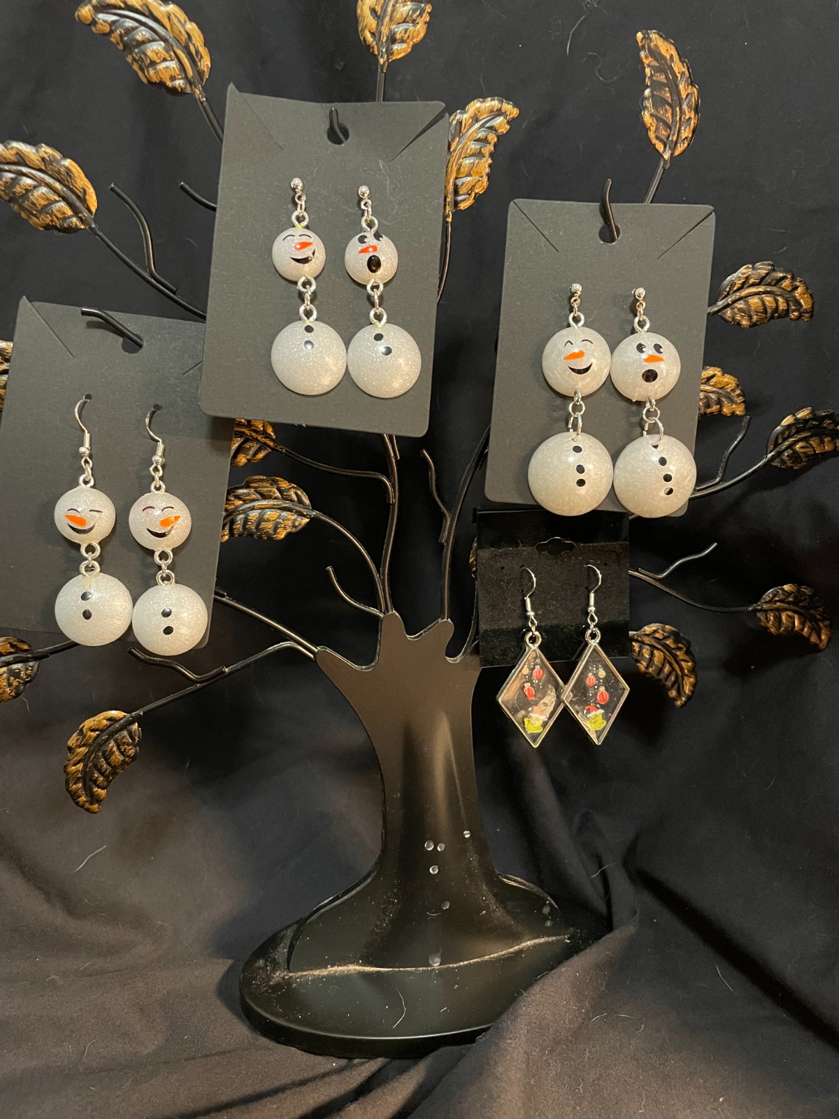 A gift box containing a selection of resin art items: a necklace, a keychain, and a magnet. The items are nestled in tissue paper. Soft, warm lighting creates an inviting atmosphere. Color palette: warm and inviting, with a focus on gold and cream tones. 4K resolution, high quality.