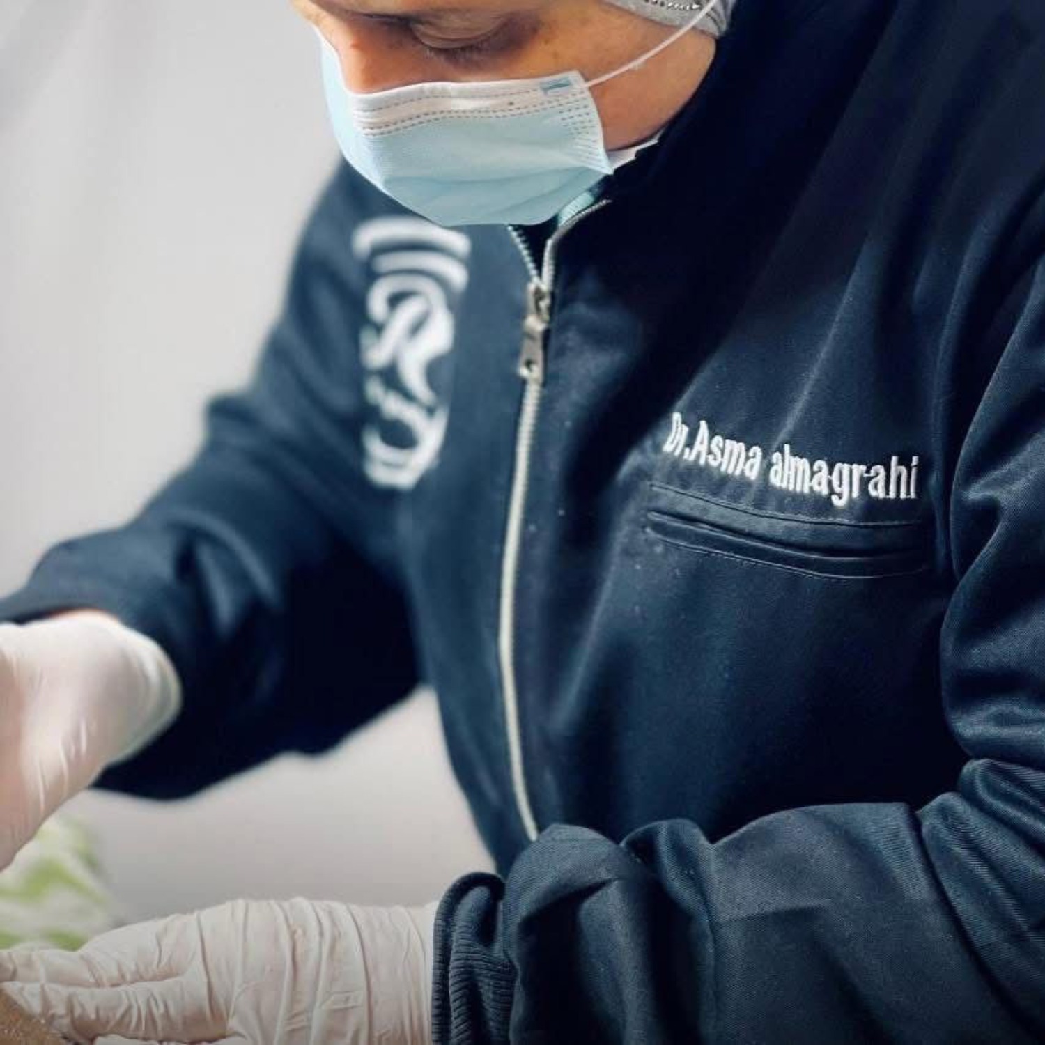A portrait of Dr. Asma Almagrahi, radiating confidence and expertise, in a modern clinic setting. The image should convey professionalism and trustworthiness.