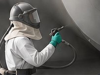 Operator spraying protective coating with an airless spray gun