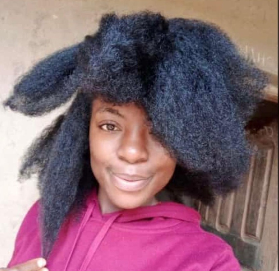 Photorealistic image of a Black woman with radiant, healthy, natural hair, exuding confidence. Natural lighting, focusing on her glowing complexion and beautiful hair.  The background is blurred, drawing attention to the woman.  High-quality 4K resolution.