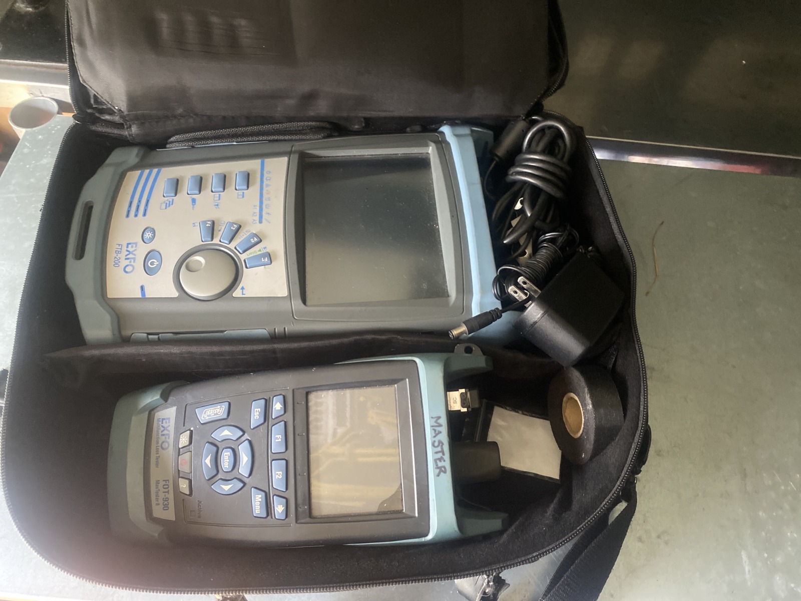 A technician using a visual fault locator (VFL) to check the integrity of a spliced fiber optic cable. The red light from the VFL should be clearly visible. Style: Technical, practical, and straightforward.