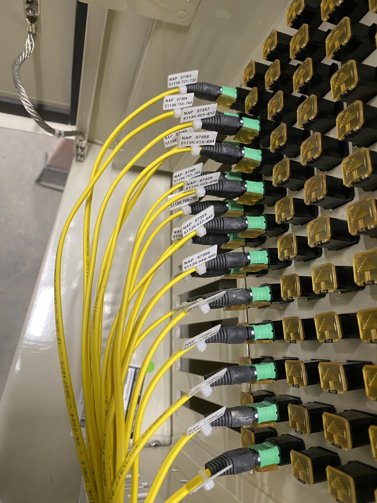 A photorealistic close-up of two perfectly aligned optical fibers being fused together within a splicing machine. Focus on the intense light at the point of fusion. Style: Technical, modern, and precise.