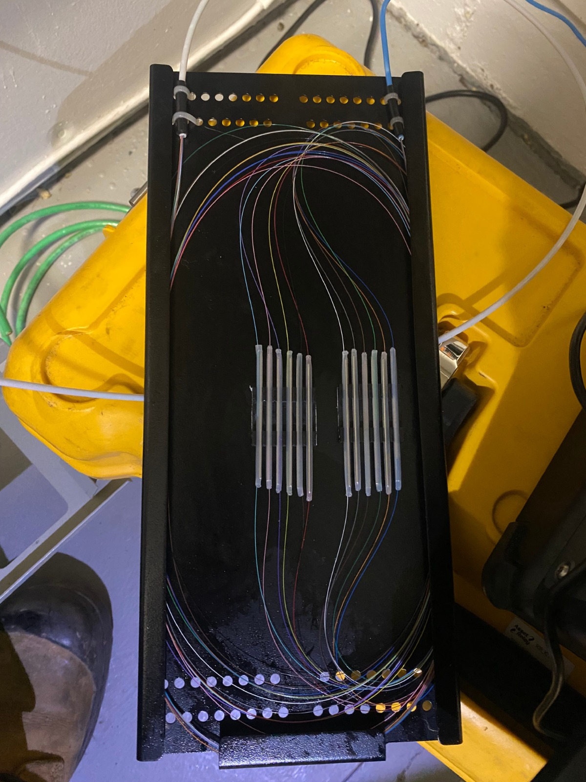 A photorealistic image of a fusion splicing machine in operation, with sparks visible as the fibers are fused together. The machine's digital display should be clear and readable. Lighting should create a sense of controlled power. Style: Modern, technical, and informative.