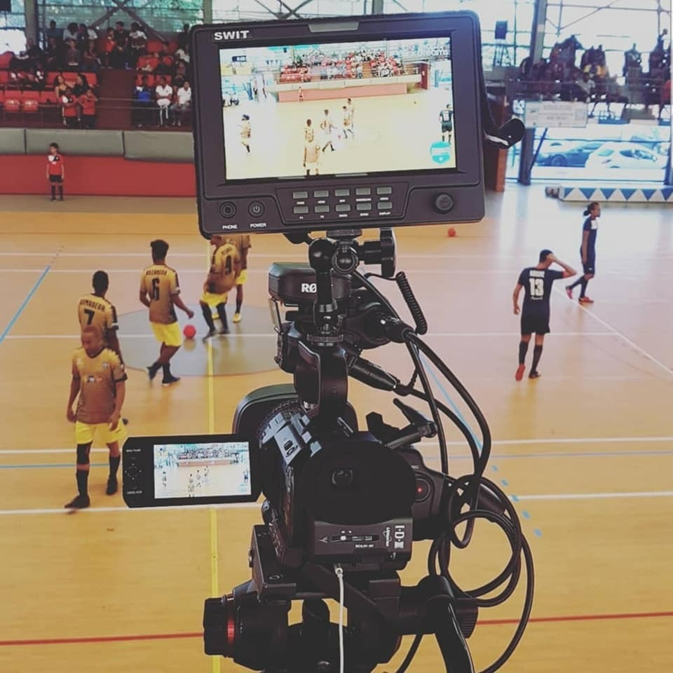 A dynamic reporting scene set in a bustling market, showcasing a journalist interviewing a local vendor. The lighting is natural, with bright sunlight illuminating the colorful produce stalls, creating a lively and authentic atmosphere. The camera angle is slightly tilted for a more engaging perspective, focusing on the interaction between the journalist and the vendor. The color palette is vibrant, showcasing a variety of fruits and vegetables, with earthy tones reflecting the market's ambiance. Textures of fabric and materials used in the market stalls add depth to the image. Environmental elements include curious onlookers and traditional market signs, enriching the narrative of community commerce. The style draws inspiration from photojournalism, capturing real-life candid moments in ultra-detail, perfect for storytelling in 8K resolution.