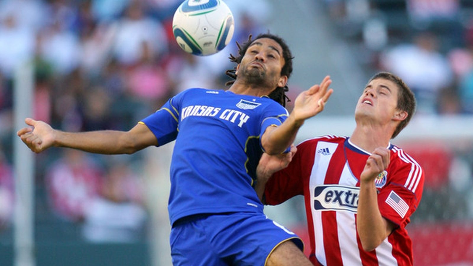 An action-packed image of a football match in a stadium, featuring Auvray in an MLS jersey, sharing the field with iconic players like Thierry Henry. The crowd is cheering, capturing the excitement and intensity of professional football.